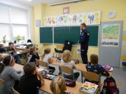 Policjant prowadzi pogadankę z uczniami w klasie.