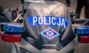 Napis &quot;POLICJA&quot; i logo ruchu drogowego na szybie motocykla policyjnego.