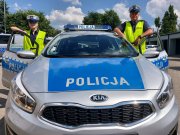 Radiowóz oznakowany oraz dwoje policjantów ruchu drogowego.