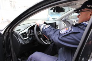 Policjant siedzi za kierownicą radiowozu
