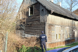 Policjant kontroluje opuszczony budynek.