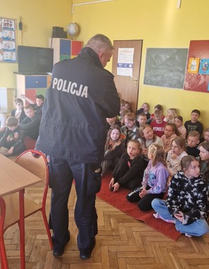 policjant rozmawia o bezpieczeństwie z dziećmi i młodzieżą podczas półkolonii