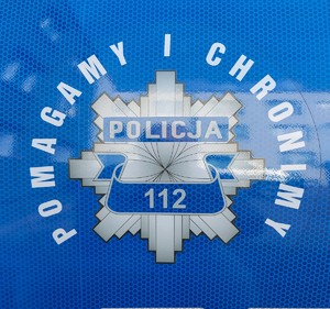 zdjęcie przedstawia logo policji na radiowozie  z hasłem Pomagamy i Chronimy